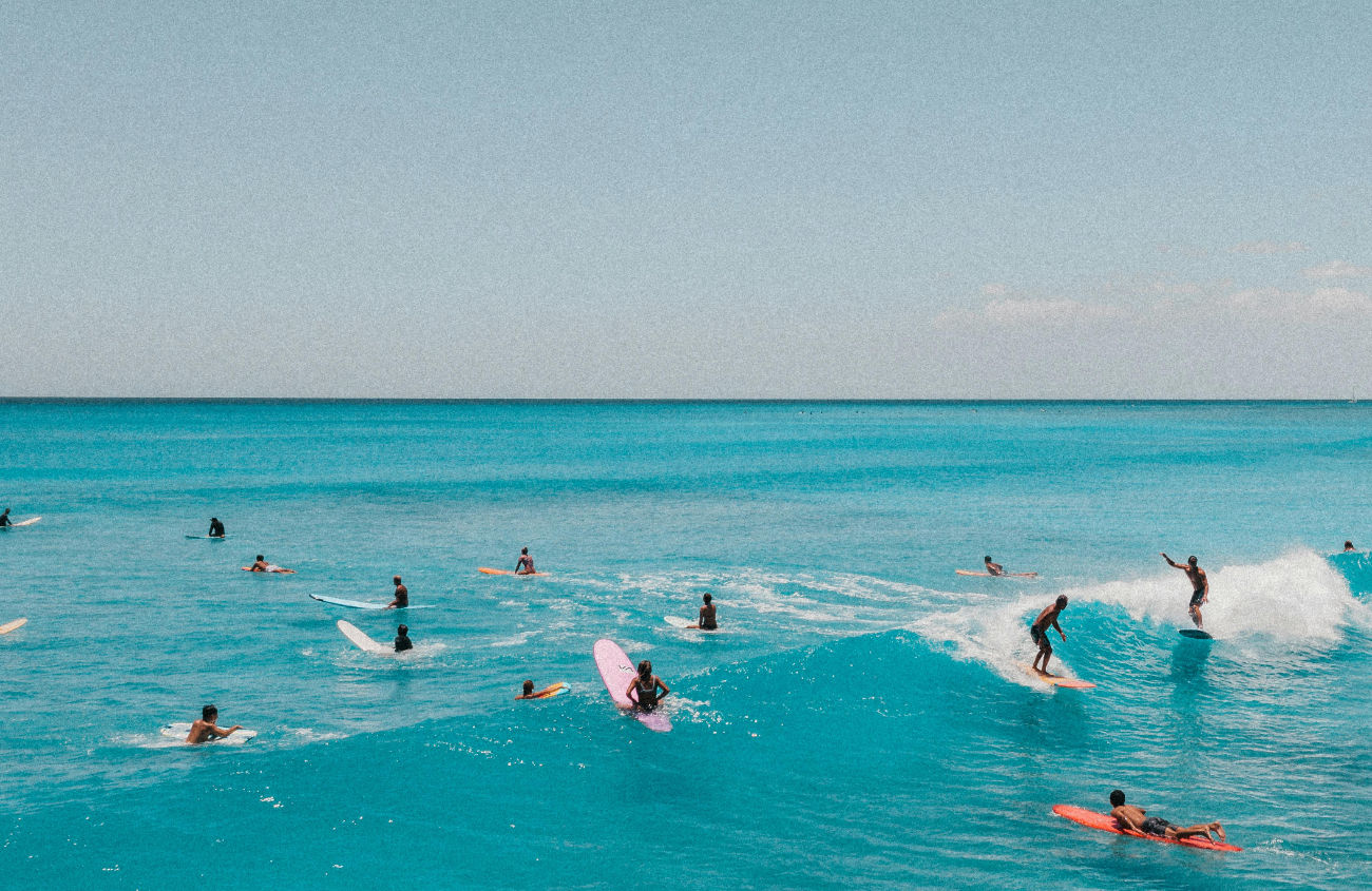 A peaceful image of surfers in the ocean, with the colors and feeling of freedom embodying the agency's core philosophy.