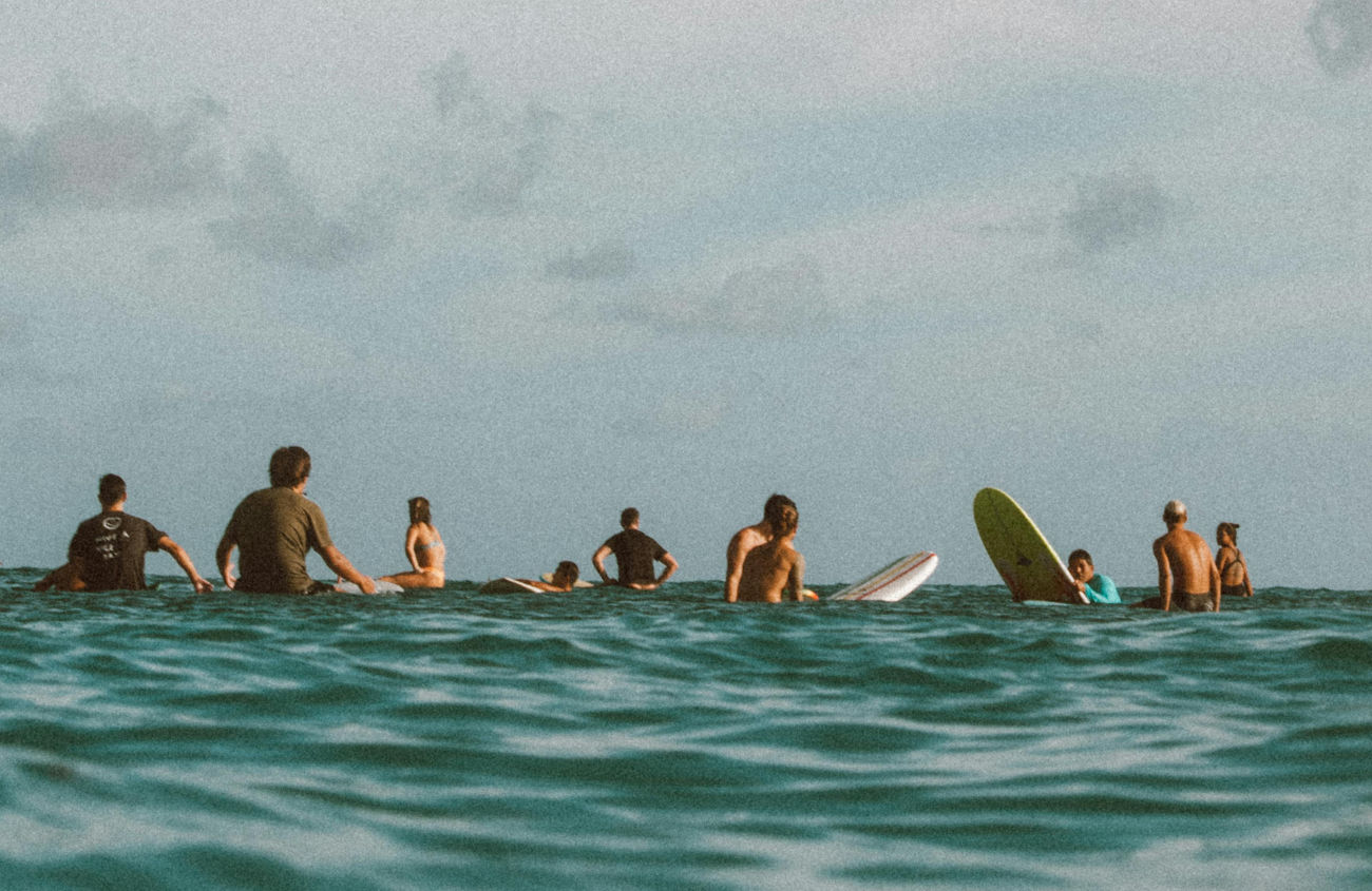 A peaceful image of surfers in the ocean, with the colors and feeling of freedom embodying the agency's core philosophy.